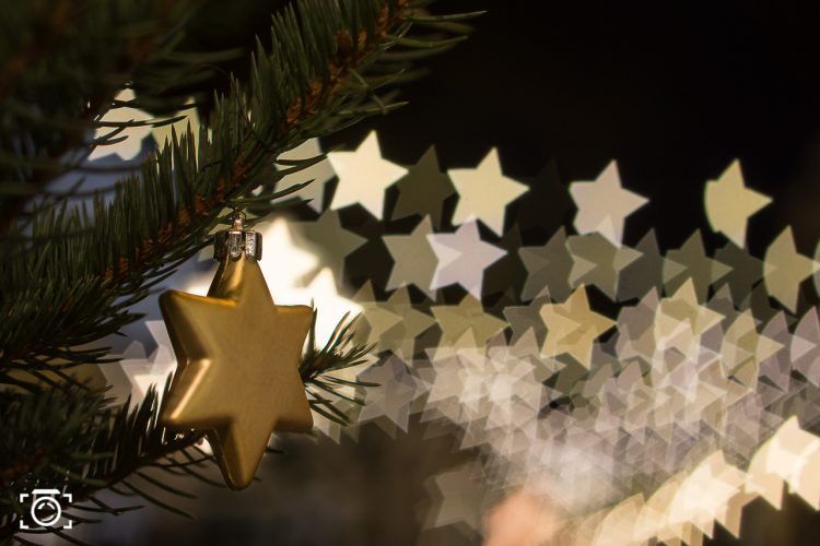 Stern an Weihnachtsbaum mit Sternen Bokeh